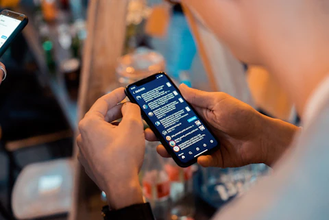 Hands holding a phone with a chat conversation on screen