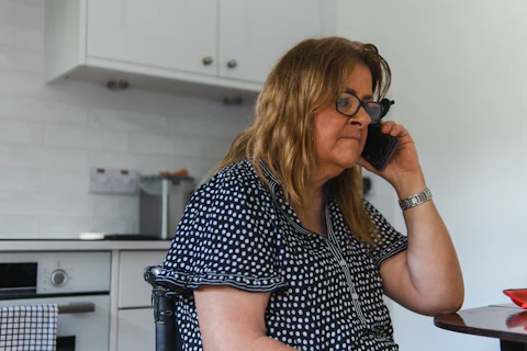 A woman on a phone call in her kitchen