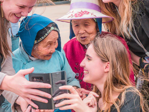Young women showing an older woman something on a phone